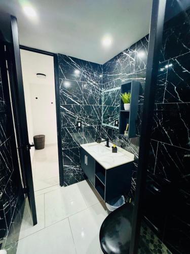 a black bathroom with a sink and a mirror at Brand New Luxe Apartment 1 in Carolina