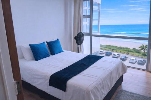 a bedroom with a bed with a view of the ocean at 32 Warnadoone- On Warner beach-Amanzimtoti in Kingsborough