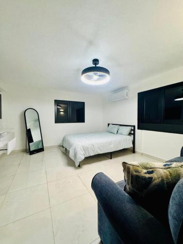 a bedroom with a bed and a couch and a mirror at Brand New Luxe Apartment 1 in Carolina