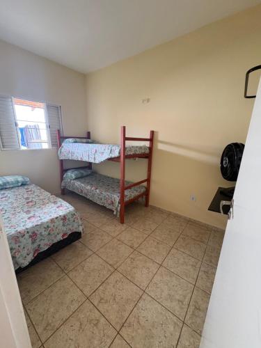 a bedroom with two bunk beds and a fan at Casa para 5 pessoas, 1 vaga de garagem, wi-fi, próximo EMS in Hortolândia