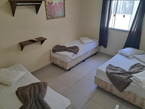 a room with two beds and a window at Pousada Mãe Ternura Palace in Aparecida