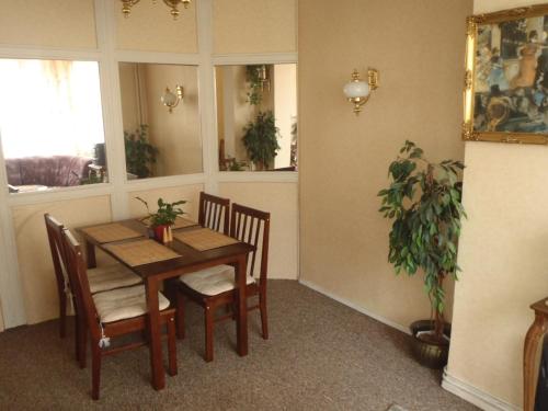 a dining room with a table and chairs and a plant at Hotel Green House in Teplice