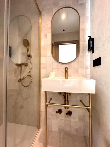 a bathroom with a sink and a shower with a mirror at Hugo Beach Hotel & Apartments in Gandía
