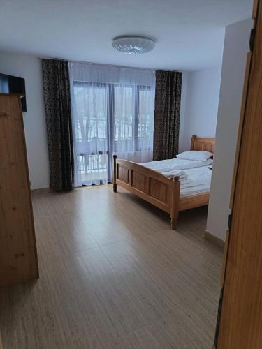 a bedroom with a bed and a large window at Mountain Breeze in Borlova