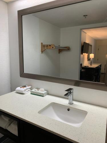 a bathroom with a sink and a large mirror at Sky Suites in Tybee Island