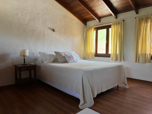 a bedroom with a white bed and a window at Costanera 61, frente a la laguna in Chascomús