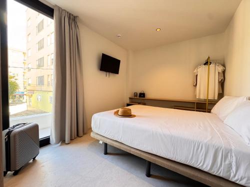 a bedroom with a bed and a tv and a window at Hugo Beach Hotel & Apartments in Gandía