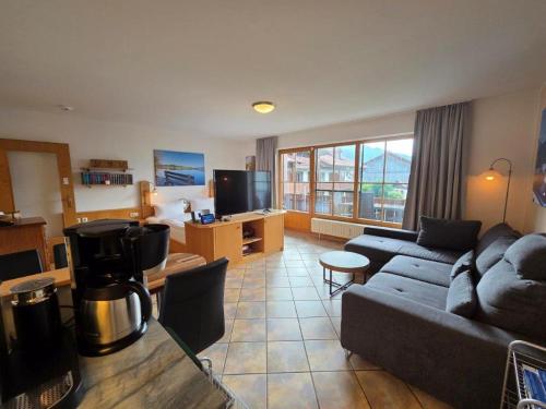 a living room with a couch and a tv at Sunshine Lodge in Pfronten