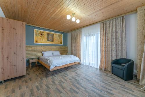 a bedroom with a bed and a chair at Forever young Bran in Sohodol