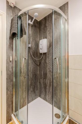 a shower with a glass enclosure in a bathroom at Acorns in Holywell