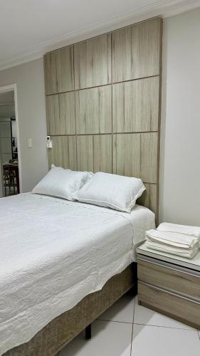 a bedroom with a large bed with a wooden headboard at Beach Garden Ap lagoa Serena in São Luís