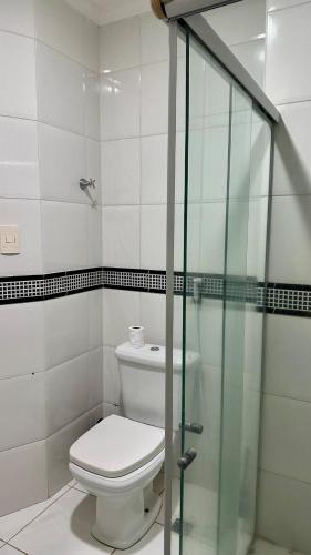 a bathroom with a toilet and a glass shower at Beach Garden Ap lagoa Serena in São Luís