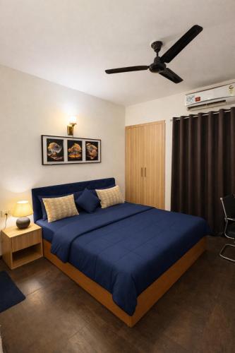 a bedroom with a blue bed and a ceiling fan at Warm Embrace in Noida