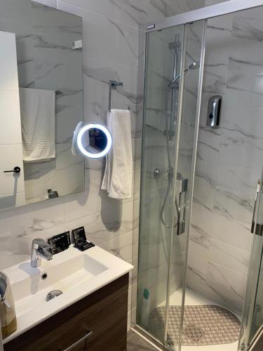 a bathroom with a glass shower and a sink at San VICENTE in Vigo