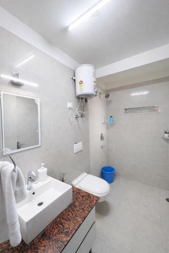 a bathroom with a sink and a toilet and a shower at Warm Embrace in Noida