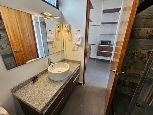 a bathroom with a sink and a mirror at Torres Mittah Oceanview Condos at La Cruz de Huanacaxtle in Cruz de Huanacaxtle