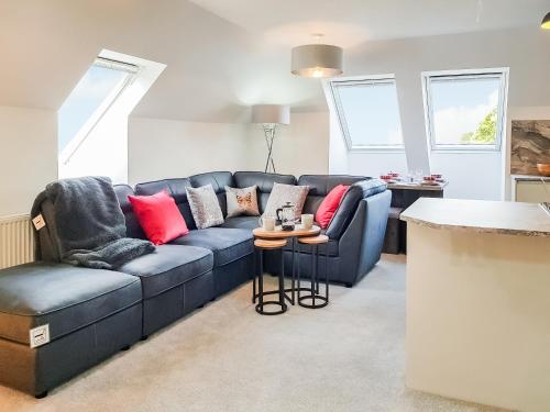 a living room with a blue couch and red pillows at Palace View - Uk40569 in Falkland