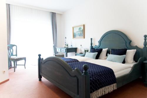 a bedroom with a large bed with a blue comforter at Landhotel Marienthaler Hof in Marienthal