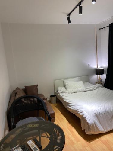 a room with two beds and a chair and a table at Clouds chase in Madinaty