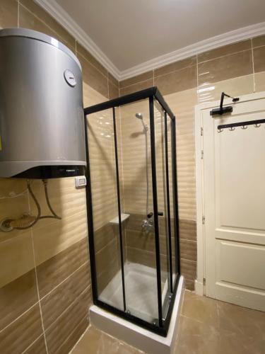 a shower in a bathroom with a glass shower stall at Clouds chase in Madinaty