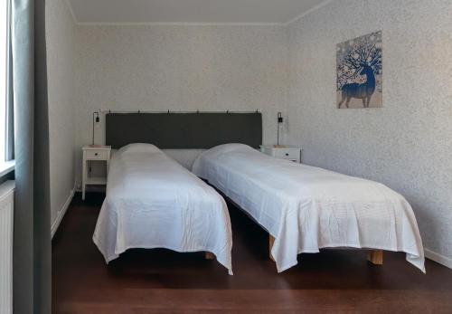 two beds in a room with white sheets at Lugnt läge i centrala Rättvik in Rättvik