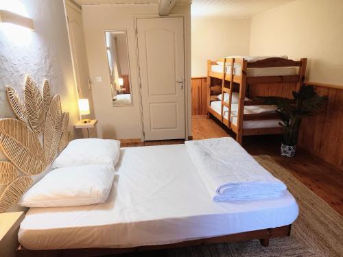 a room with two beds and a bunk bed at L'âne à plumes in Coisia