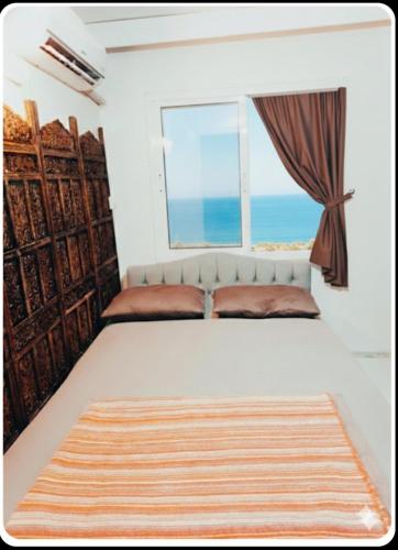 a bedroom with a large bed with a window at AFİFE Apart, Kusadasi,Denize ve Plaja Sıfır in Kuşadası