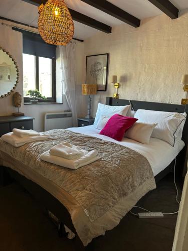 a bedroom with a large bed with towels on it at Smugglers Cottage converted Barn with Pool & Jacuzzi NR Lyme Regis in Whitchurch Canonicorum