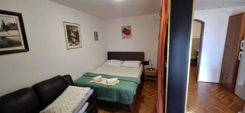 a small room with a bed and a couch at Apartman Lea in Crikvenica