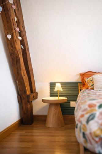 a bedroom with a bed and a table with a lamp at Chambre privée, A l'ombre des Pommiers in Croix-Mare