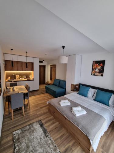 a bedroom with a large bed and a living room at SKYLINE apartments Kopaonik in Kopaonik
