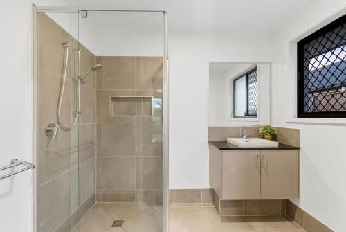 a bathroom with a shower and a sink at JOT Luxe Haven in Narangba