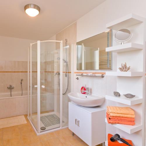 a white bathroom with a shower and a sink at Ferienhaus Herbert in Groß Kordshagen