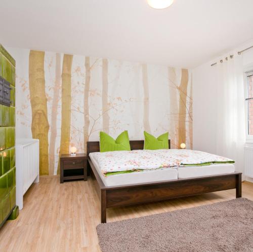 a bedroom with a bed with green pillows at Ferienhaus Herbert in Groß Kordshagen