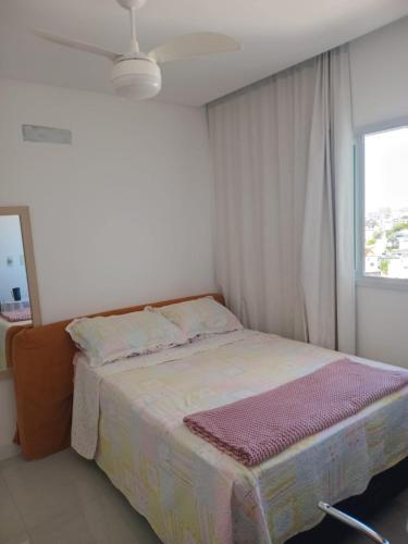 a bedroom with a bed with a window and a ceiling at Quarto próx a Praia do Morro in Guarapari