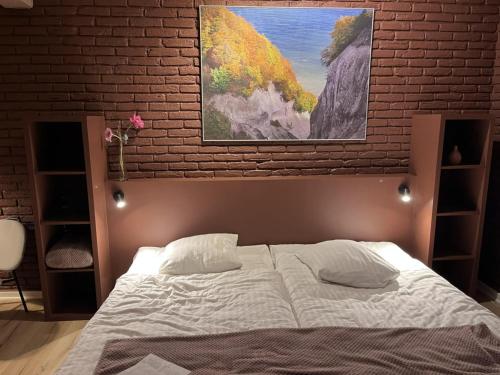 a bedroom with a bed and a brick wall at Møn Klintholm Vintage B&B in Borre
