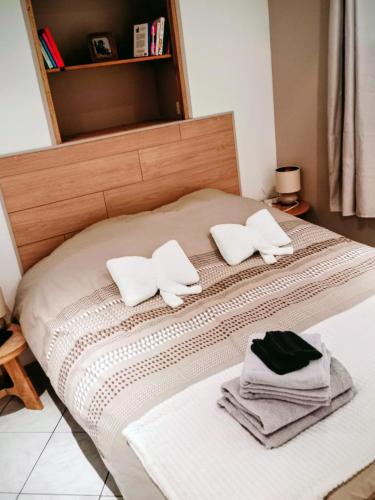 a bed with white pillows and towels on it at Appartement cosy et confortable Chez Lyne in Laragne
