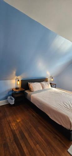 a bedroom with a bed with a blue wall at The Stirton House in Shelburne
