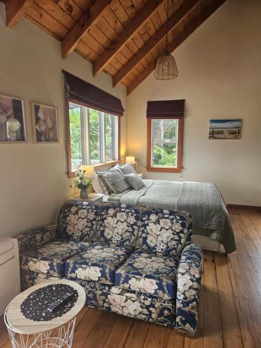 a living room with a bed and a couch at The Blackhouse Cottage in Hokitika