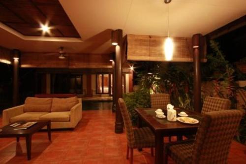 a living room with a couch and a table and chairs at Kalicaa Villa Resort, Tanjung Lesung in Tanjung Lesung