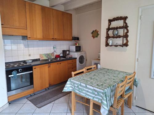 a small kitchen with a table and a microwave at Petite maison proche cathédrale hyper centre in Toul