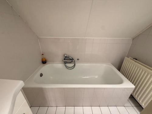 a white bath tub with a faucet in a bathroom at Wellness huis voor 6 personen aan het strand 'Zeeuwse Rust' in Wemeldinge