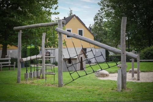 a park with a swing set in front of a house at Wellness huis voor 6 personen aan het strand 'Zeeuwse Rust' in Wemeldinge