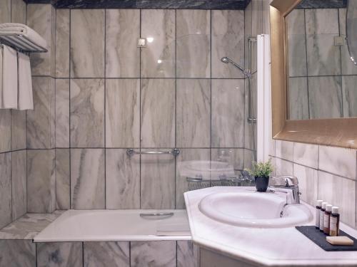 a bathroom with a sink and a shower at Hotel Du Lac Congress Center & Spa in Ioannina