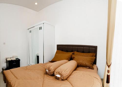a bed with pillows on it in a bedroom at Haus Strahlende Villa in Batu