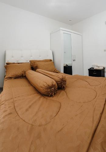 a large bed with brown pillows on top of it at Haus Strahlende Villa in Batu