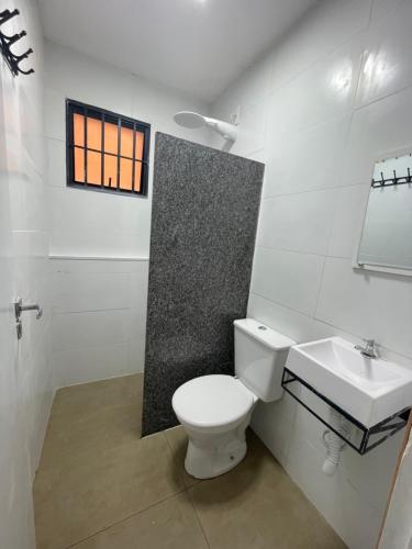 a bathroom with a white toilet and a sink at kit net central 1 in Serra Negra