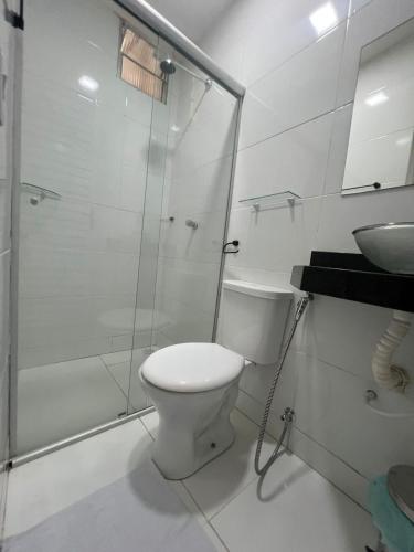 a bathroom with a toilet and a shower and a sink at Hostel Cünhatã in Belém