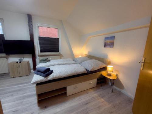 a bedroom with a bed and a window and a television at HanseSuite zentral & charmante Ferienwohnung in Lübeck