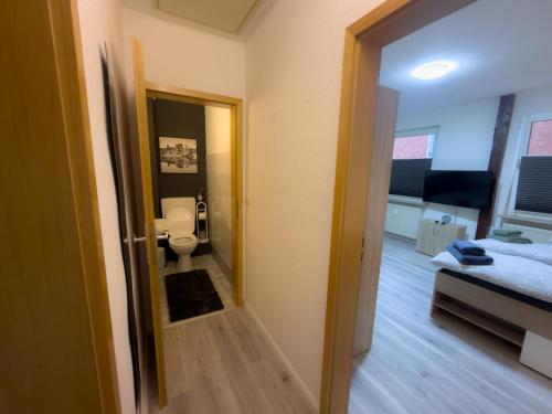 a bathroom with a toilet and a room with a bed at HanseSuite zentral & charmante Ferienwohnung in Lübeck